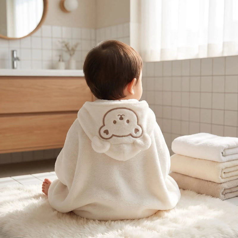 Cape de bain bebe. Bebe est recouvert de son cape de bain bebe